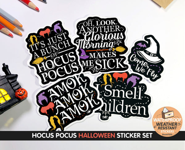 A set of 4 Hocus Pocus stickers for Halloween on a white table with Halloween decor. These vinyl decals depict quotes from the Sanderson Sisters in modern white text, and minimalist hairstyles in orange purple and gold on a smooth black background